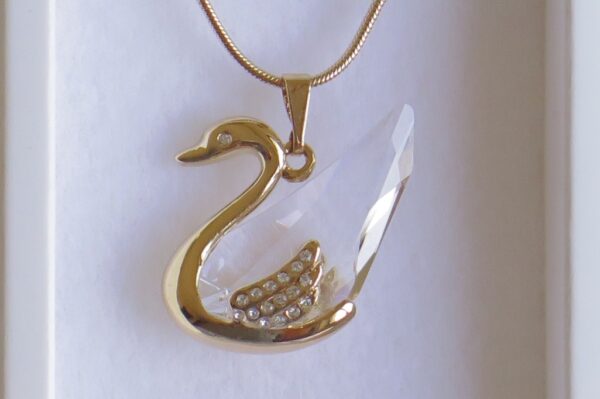 Ogrlica od Swarovski elemenata s privjeskom od labuda prozirnih nijansi koje svjetlucaju, dok mu je osnova zlatne boje.