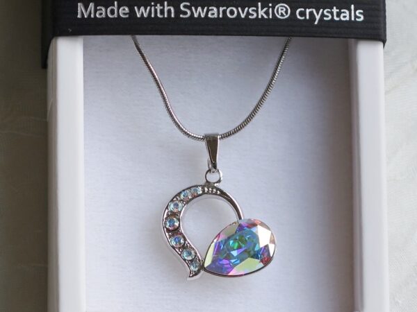 Ogrlica od Swarovski elemenata u obliku srca, prelijevajućih roskasto-plavih nijansi boja s metalik sjajem.