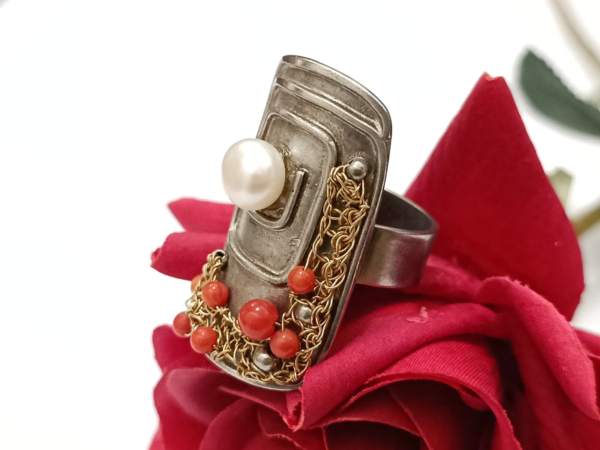 Unikatan srebrni prsten izrađen od crvenog jadrasnkog Koralja i srebra 925 finoće. Eleganciju mu daje perla od kulitivranog bisera. Hrvatski tradicijski komad nakita suvremene ljepote.