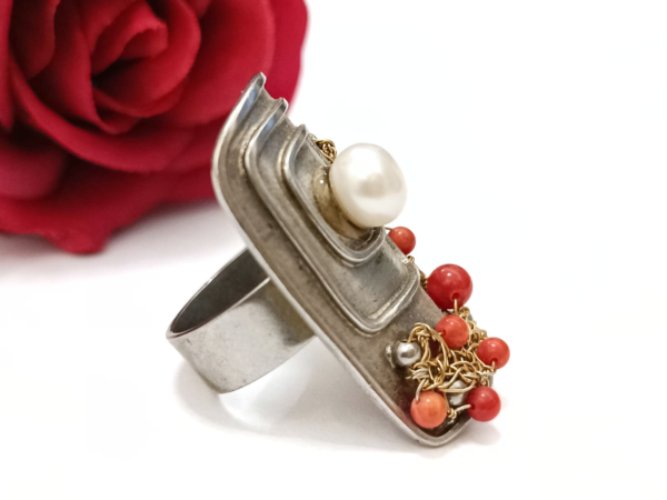 Unikatan srebrni prsten izrađen od crvenog jadrasnkog Koralja i srebra 925 finoće. Eleganciju mu daje perla od kulitivranog bisera. Hrvatski tradicijski komad nakita suvremene ljepote.