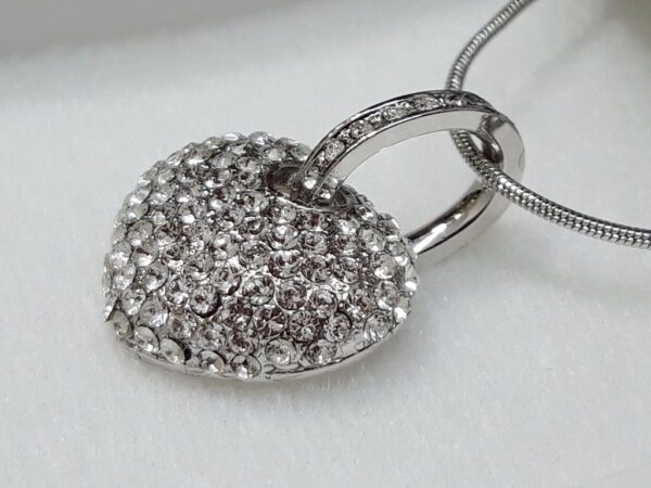 Ogrlica sa privjeskom srca od Swarovski kristala srebrno-prozirnih boja.
